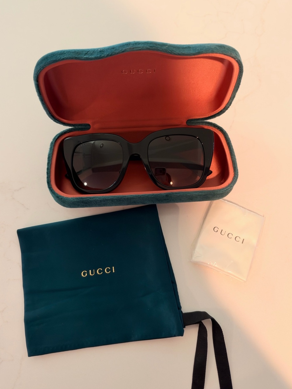 Gucci Womenās Black Cat-Eye Sunglasses with Teal Case